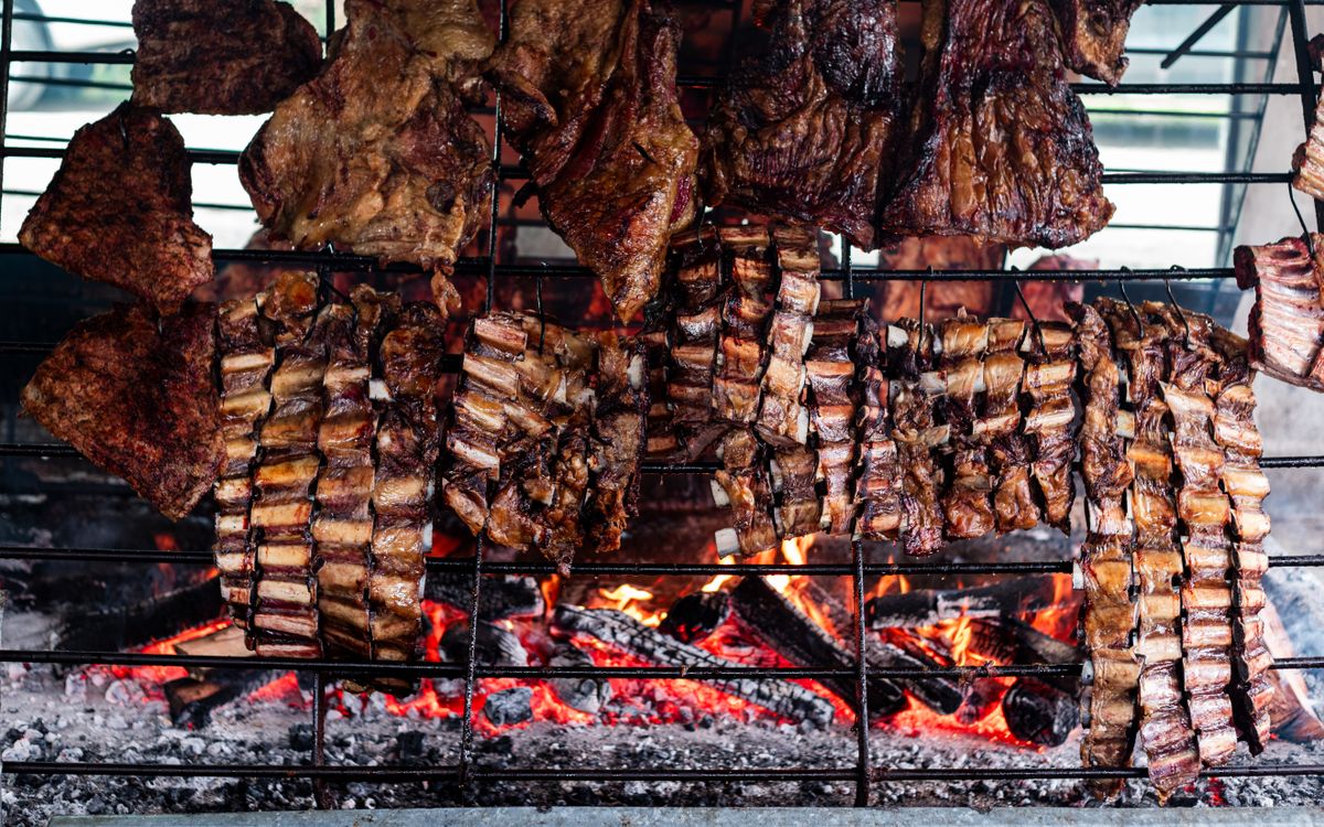 Parrilla cargada de costillares sobre las brasas