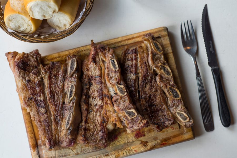 Asado de tira cortado sobre tabla de madera